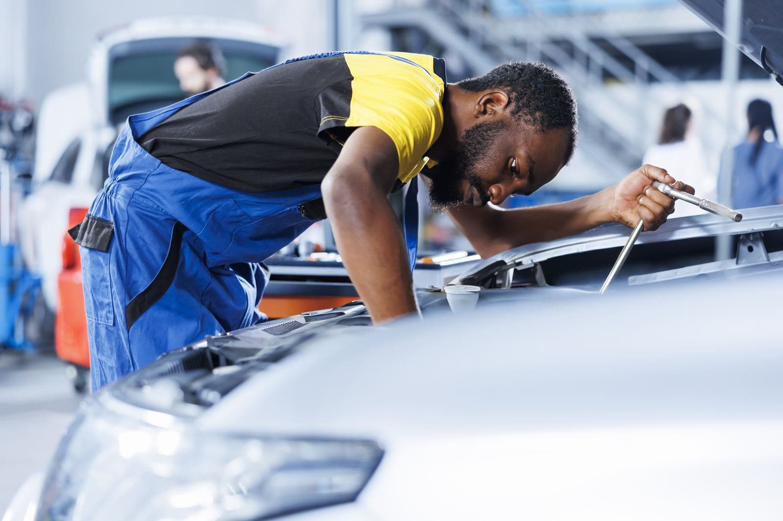 Technician working under the bonnet of a vehicle